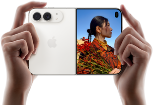 iPhone Duo, kleur Sterrenwit, met twee handen vastgehouden in liggende stand, opengevouwen, linkerkant met 48-MP Dual Fusion-camera’s aan de achterkant, op het buitendisplay rechts staat iemand die wordt gefotografeerd en dankzij Duo Preview tegelijkertijd zichzelf kan zien
