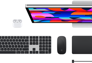 Bovenaanzicht van Mac-accessoires: Studio Display, AirPods, Magic Keyboard, Magic Mouse en Magic Trackpad